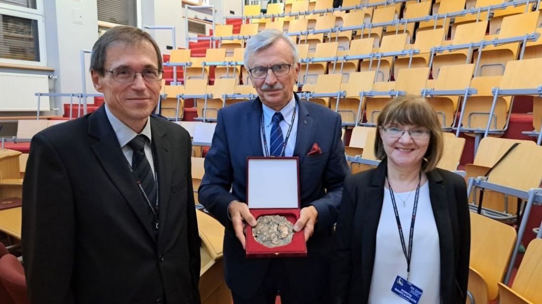 w sali wykładowej prof. Marciniak prezentuje do zdjęcia otrzymany medal