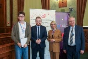 na zdjęciu laureat olimpiady i organizatorzy