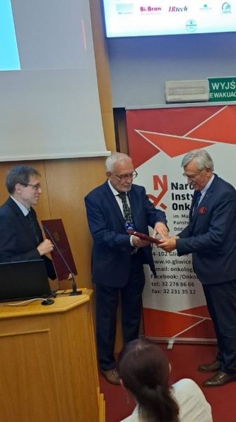 na zdjęciu moment wreczenia laureatowi medalu