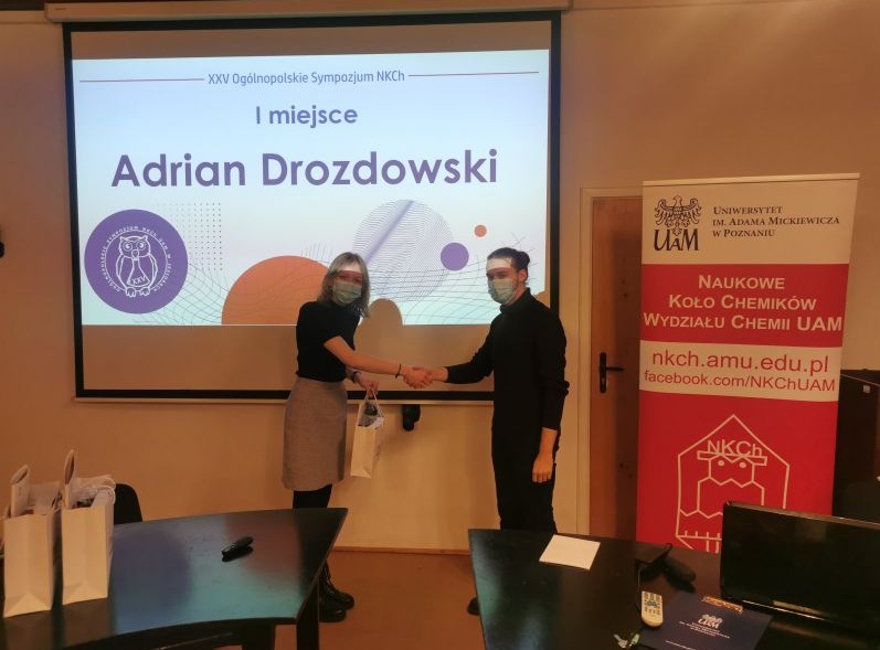 w sali na tle ekranu na którym wyświtlono 1 miejsce Adriana Drozdowskiego gratulacje przyjmuje laureat  