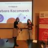 w sali na tle ekranu z wyświetlonym 2 miejscem Barbara Kaczmarek, gratulacje przyjmuje laureatka