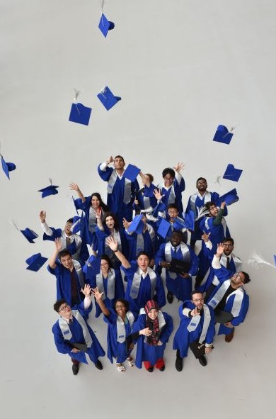 na fotografii grupa osób kończących studia w togach 