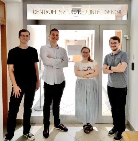 zdjęcie członków zespołu na tle korytarza Centrum Sztucznej Inteligencji
